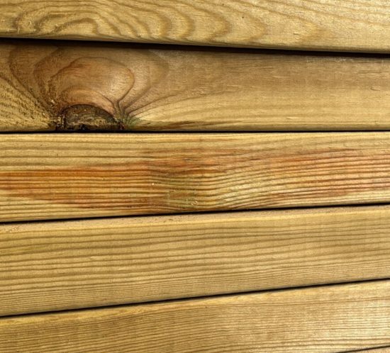 Vigas de pino estructural clasificado C24 apiladas en almacén de madera con marcado CE visible